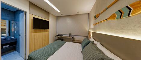 A modern hotel room with a bed, bedside table, and a mounted television.