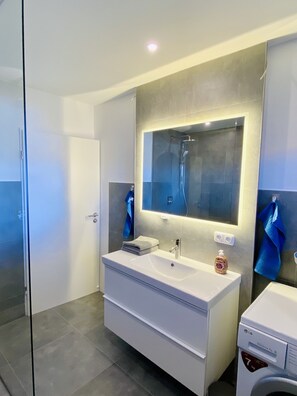 Een douche, een haardroger, pantoffels, handdoeken