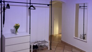 A bedroom with a bed, a dresser, a mirror, a hanging light fixture, and a ceiling light.