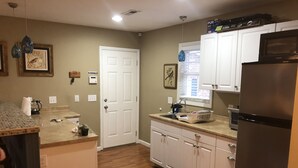 A kitchen with a refrigerator, microwave, sink, and cabinets. - Leafy, Suburban Abode (Greensboro)