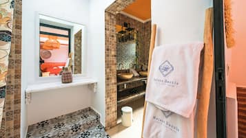 Une salle de bain avec des carreaux décorés, une fenêtre donnant sur un beau paysage, un lavabo et un porte-serviettes avec des serviettes.