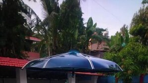 A man sitting on an inflatable pool with shark designs, under a blue umbrella. - Holy Trinity - Serviced Villa (Kundara)
