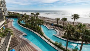 A resort pool area with a view of the beach and ocean.
