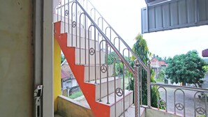 A staircase with metal railings and a red and white color scheme. - OYO 91111 Als Hotel (Lempuing)