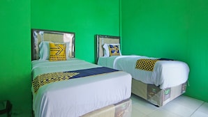 Two twin beds with headboards, white bedding, and patterned throw pillows against a green wall. - OYO 91111 Als Hotel (Lempuing)