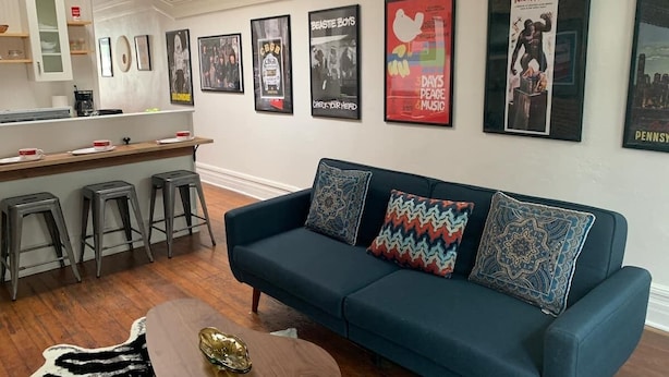 A modern living room with a blue sofa, a wooden coffee table, and a kitchen area with stools. - Lower East side NYC in Old Bisbee (Bisbee)