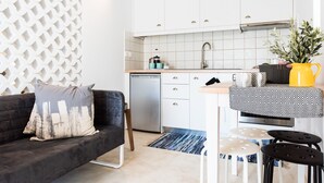 Una cocina moderna con armarios blancos, un lavavajillas de acero inoxidable y un mantel blanco y negro sobre la encimera.