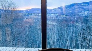 Vista d'una habitació amb una finestra gran que donava sobre un paisatge nevat i muntanyes.
