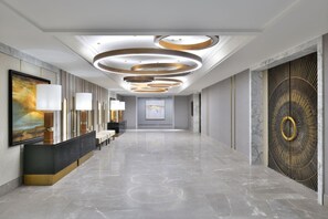 A hotel lobby with a reception desk, seating area, and a large decorative wall. - The Westin Resort & Spa, Himalayas (Narendranagar)