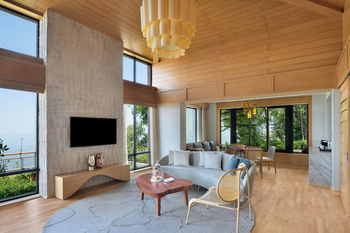 A spacious living room with a large TV, a cozy sofa, and a dining area.