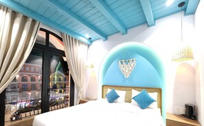 A bedroom with a large bed, a view of a cityscape through a glass door, and a blue ceiling. - Riverside Mini Hotel Grand World (Phu Quoc)