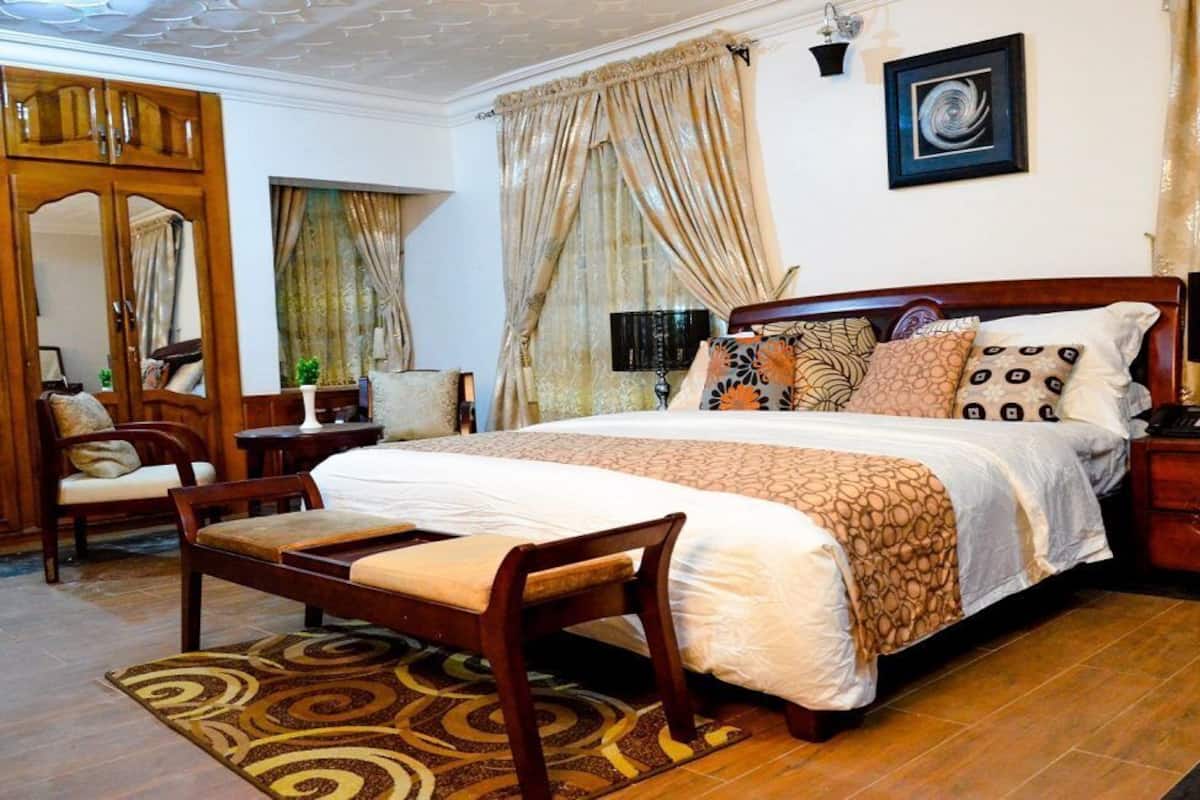 Une chambre spacieuse avec un grand lit, des meubles en bois et une vue sur l’extérieur.