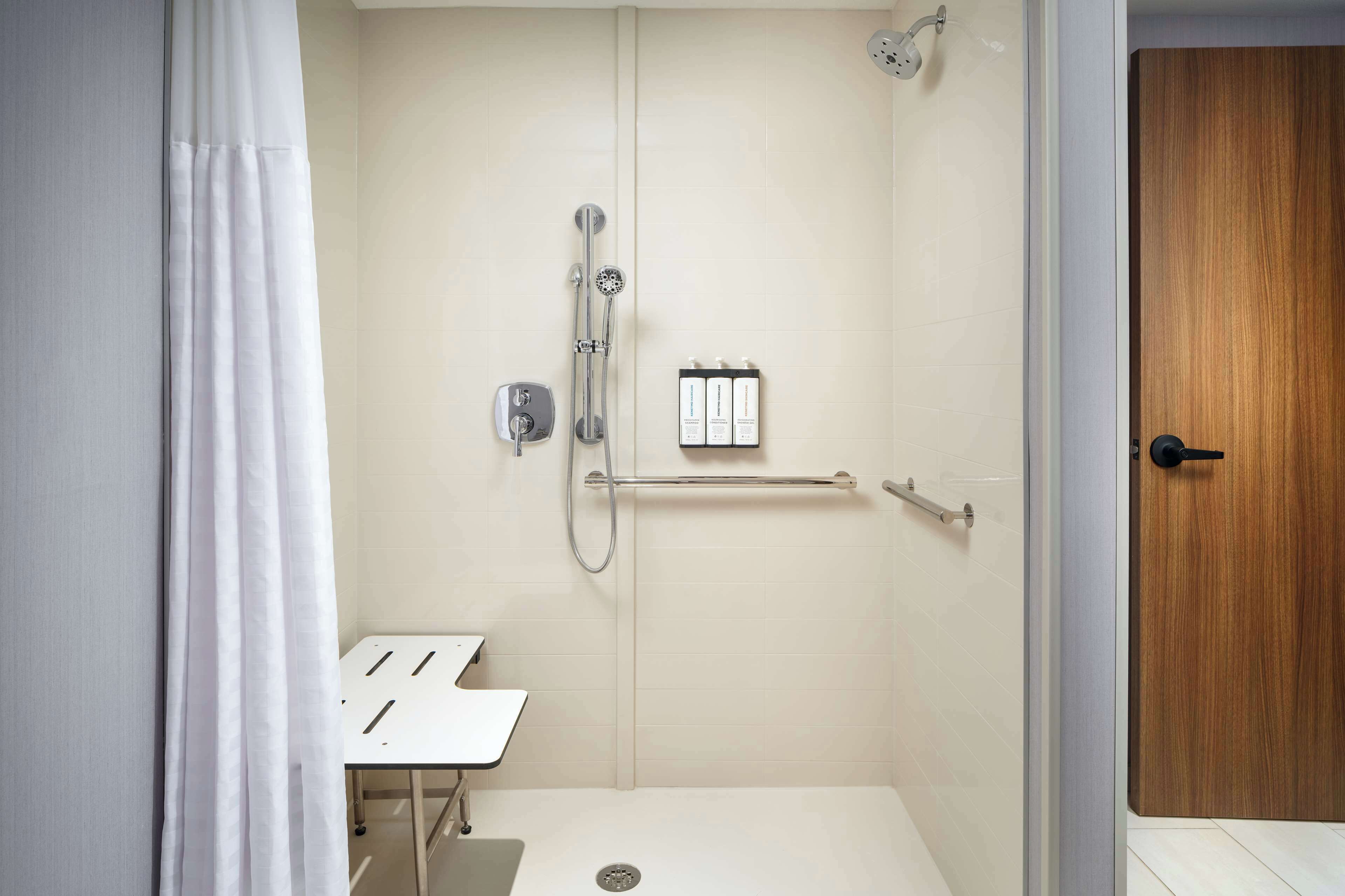 A modern bathroom with a shower, a toilet, and a sink.