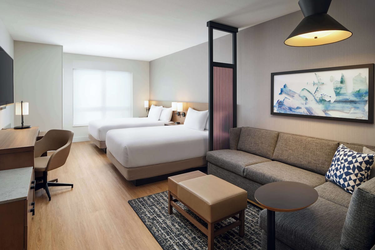 Een hotelkamer met een bed, een bank, een bureau en een stoel.
