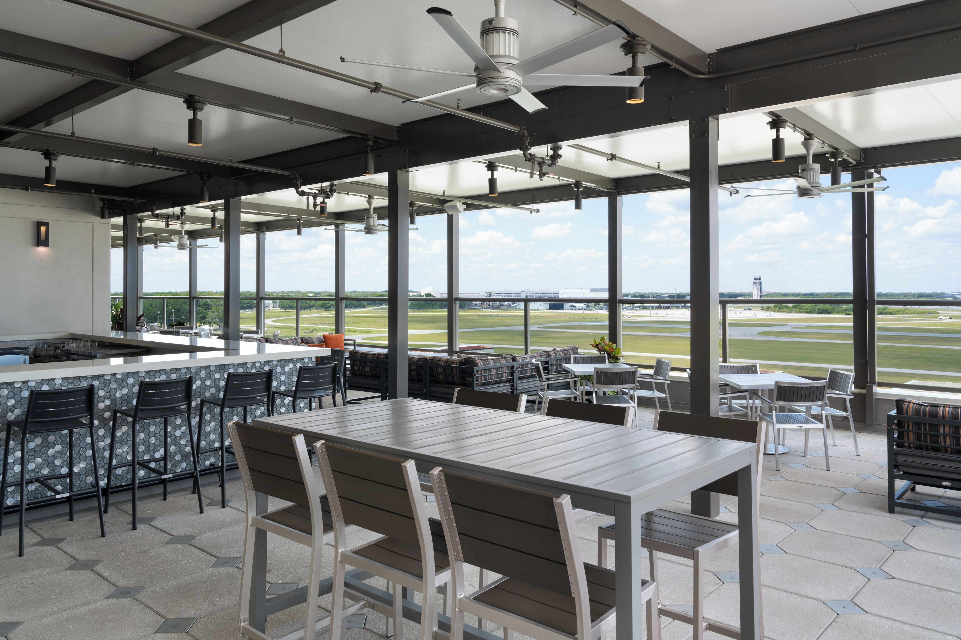 A spacious outdoor dining area with a view of a sports field.