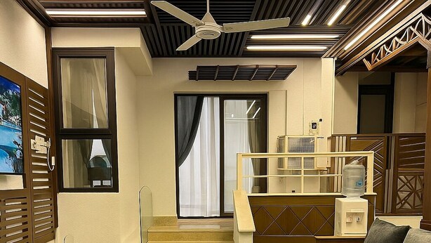 A modern interior with a staircase, a sofa, and a water dispenser. - A Piece of Paradise in Porto Said (Al-Manasrah)