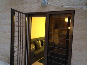 An open door leading to a room with a sofa and a wall-mounted light fixture.