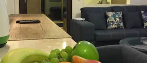 A room with a wooden table, a couch, and a view into another room.