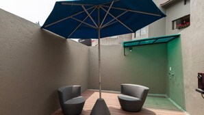 A small outdoor seating area with two wicker chairs and a blue umbrella. - Room in Guest Room - Cuarto En Las Lomas! (Naucalpan)
