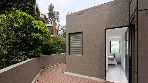 A modern building with a wooden deck, a small window with blinds, and a view into a room with a bed. - Room in Guest Room - Cuarto En Las Lomas! (Naucalpan)