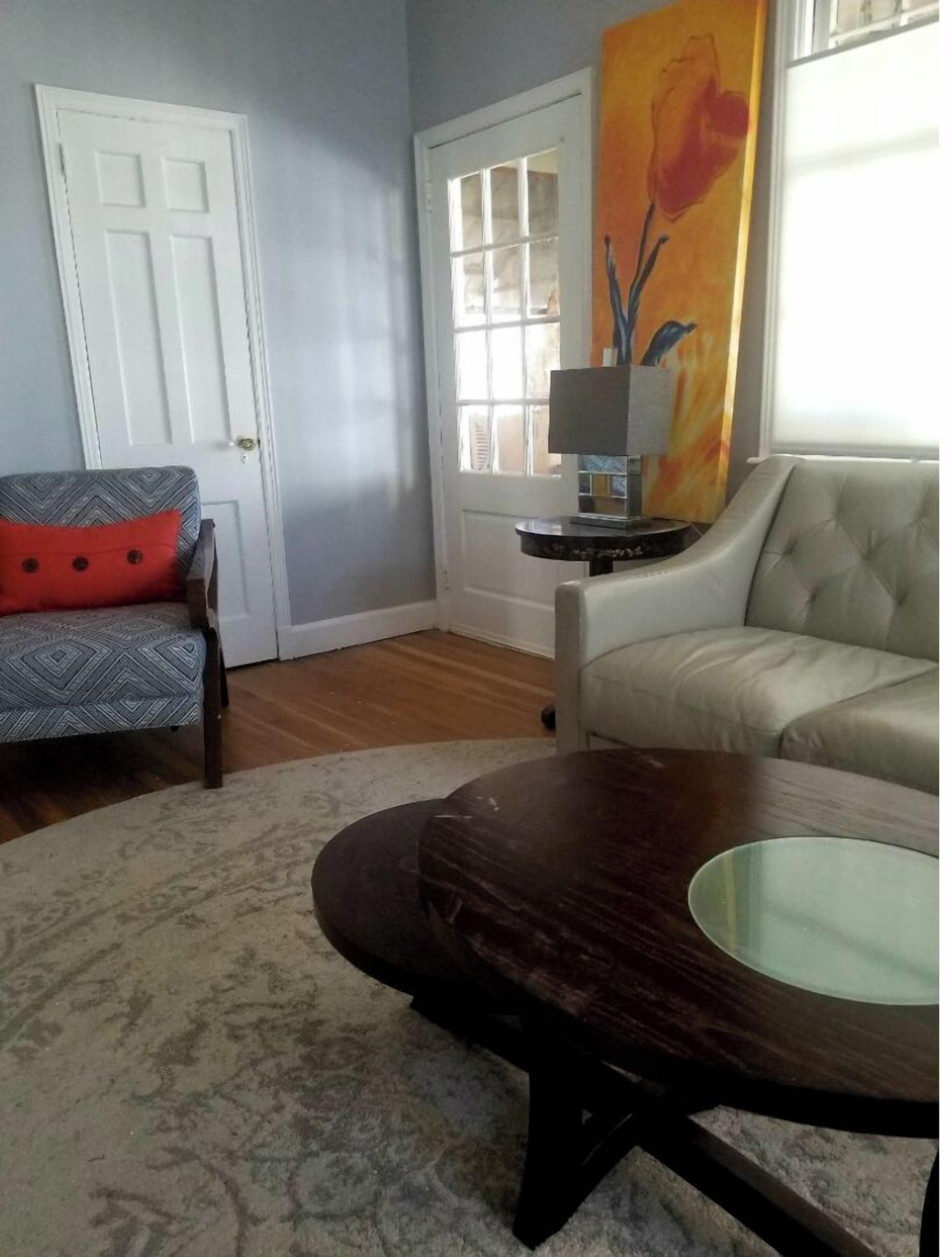 Een woonkamer met een bank, fauteuil en salontafel.