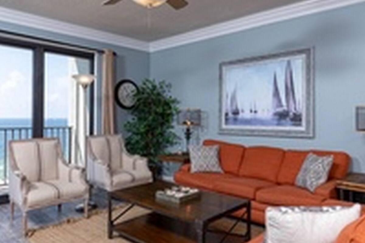 Ein Wohnzimmer mit großem Fenster, einer Couch, einem Sessel und einem Couchtisch.