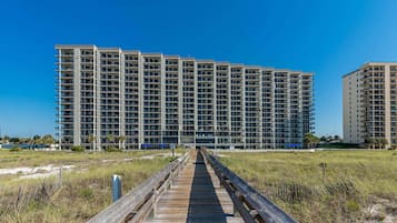 A multi-story hotel with a central walkway leading to the entrance.