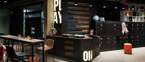 Un área de lounge moderna con bar, asientos y taquillas.