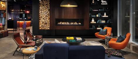Un área de descanso moderna con chimenea, asientos y barra.