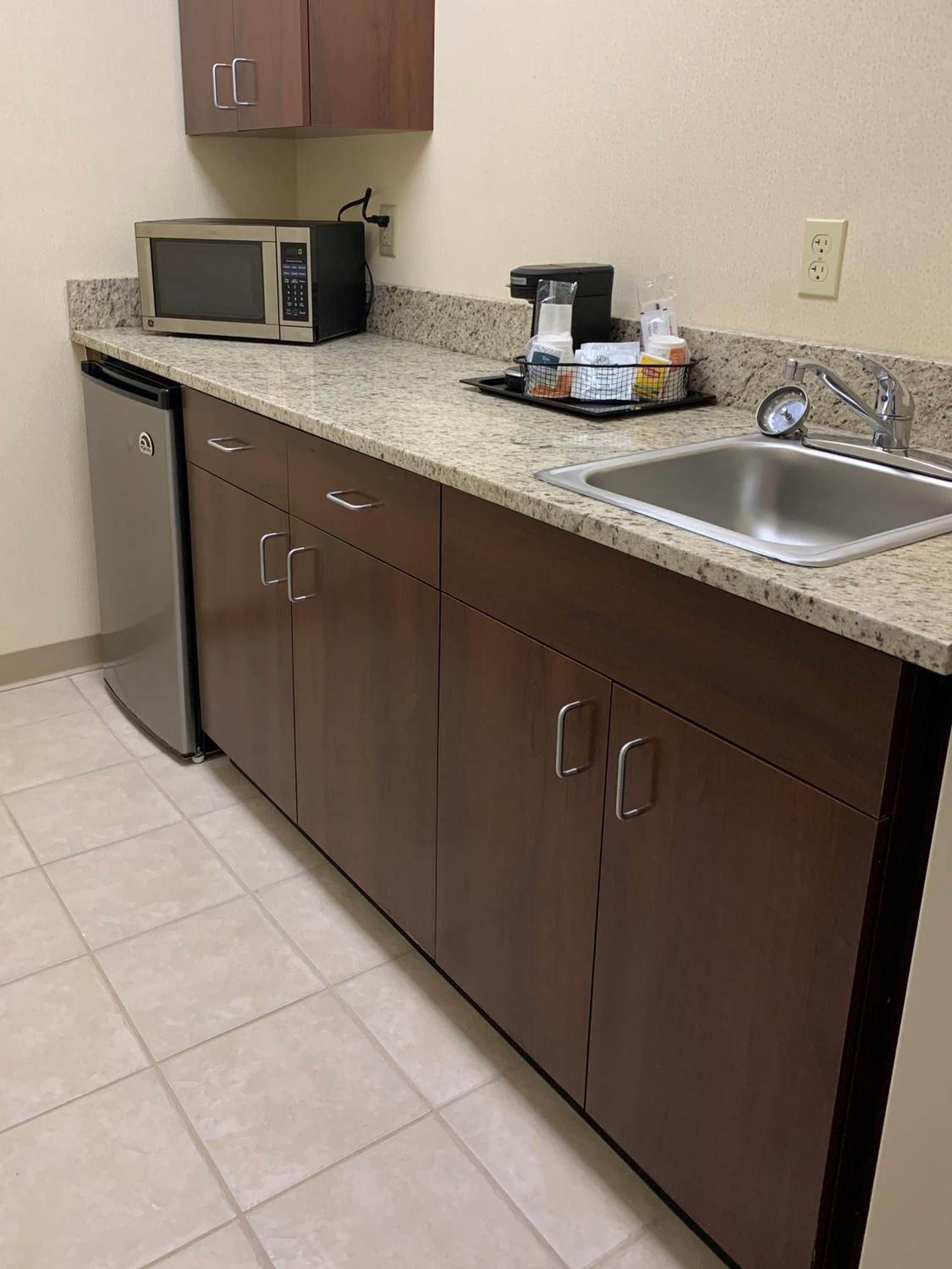 A kitchen with a microwave, sink, and dishwasher.