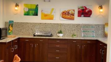 Cocina con encimeras de granito, armarios de madera y luminarias empotradas.