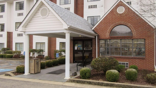 A multi-story building with a covered entrance, a brick section, and a large window. - Quality Inn & Suites Prestonsburg (Prestonsburg)