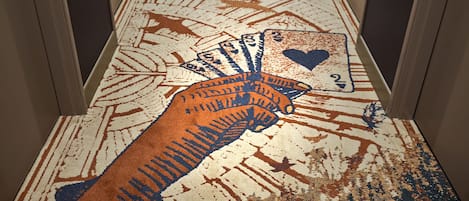 A carpet with a hand holding playing cards.