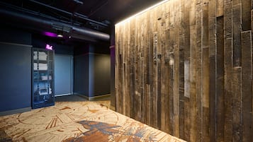A modern lobby with a wooden wall and a patterned carpet.