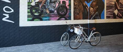 A mural with a bicycle parked in front.
