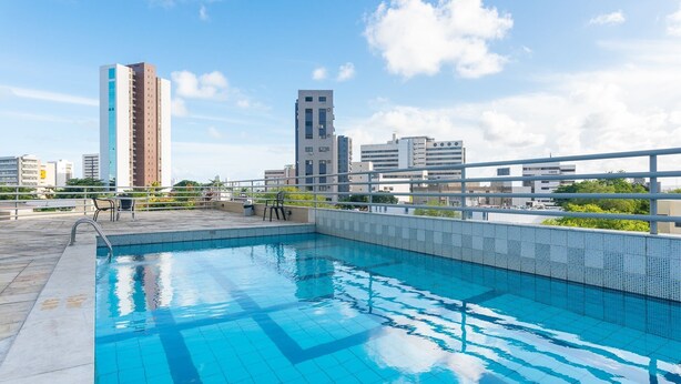 A rooftop swimming pool with a cityscape view, surrounded by modern buildings and a clear sky. - Flat na Ilha do Leite, Recife 1 quarto. Conforto e Excelente localização OTH1205 (Recife)