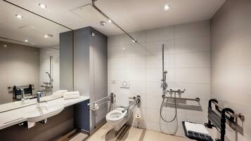 Un baño moderno con inodoro, lavamanos y ducha.