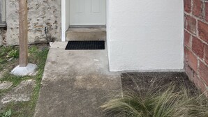 A residential building with a white door, a small window, and a tiled roof. - Air-conditioned house near RER / Paris / Disney / CDG (Gagny)