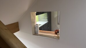 A mirror reflecting a kitchen area with a white countertop, a roll of paper towels, and a wicker basket. - Air-conditioned house near RER / Paris / Disney / CDG (Gagny)