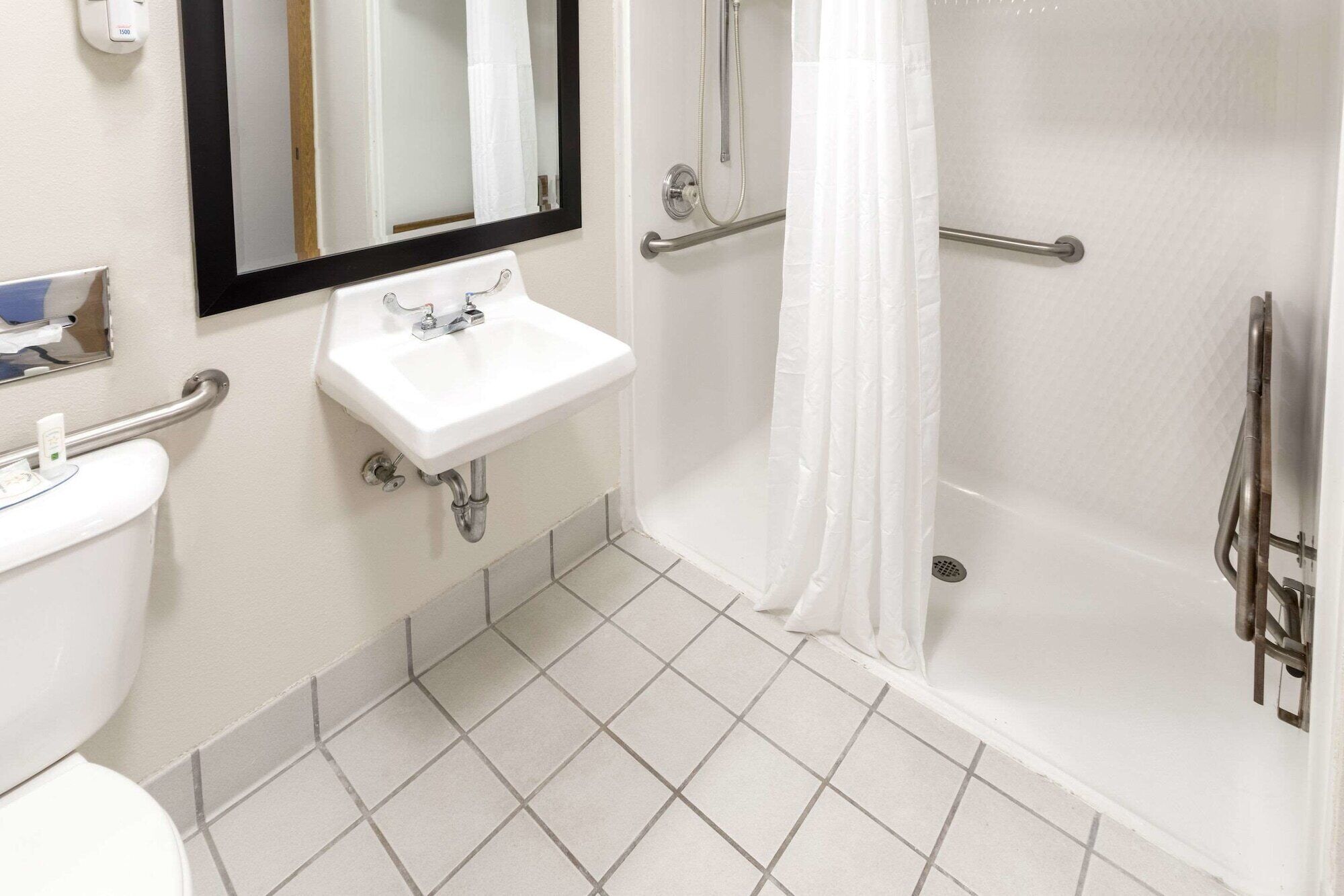 A bathroom with a white sink, mirror, and toilet.