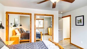 A bedroom with a bed, wooden headboard, a ceiling fan, and a large mirror. - Cozy Belgrade Home Near Skiing, Hiking & Airport! (Belgrade)