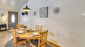 A dining area with a wooden table set for four, surrounded by chairs with cushioned seats. - Cozy Belgrade Home Near Skiing, Hiking & Airport! (Belgrade)