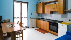 A compact kitchen with wooden cabinets, a stove, and a refrigerator. - Inviting 1-bed Apartment With Box and Seeviews (Ranzanico)