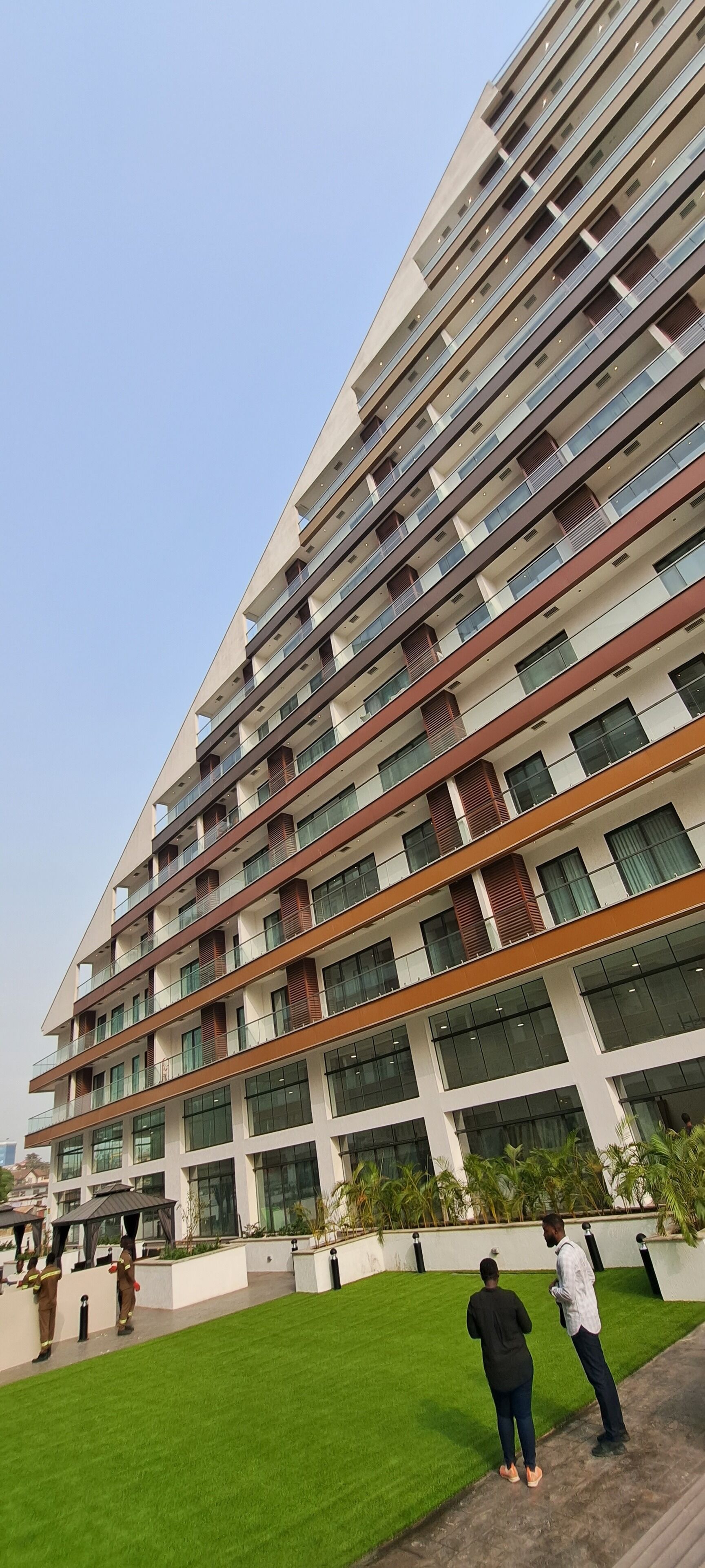 Un immeuble à plusieurs étages doté d’une architecture moderne, avec des balcons et de grandes fenêtres.