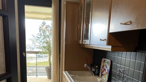 A compact kitchen with a sink, stove, and cabinets.