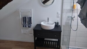 A bathroom with a white sink, a mirror, and a towel rack.