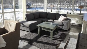 En hyggelig stue med en hjørnesofa, et sofabord og en pejs.