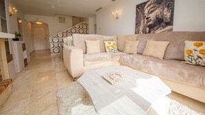 Ein modernes Wohnzimmer mit einem beigen Sofa, einem weißen Couchtisch und einer Wand mit Muster.