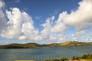 A coastal landscape with a clear sky, a body of water, and a sailboat. - Costa Bonita Private Villa 604 (Culebra)