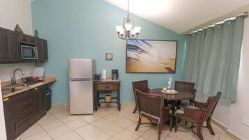 Frigorífico, placa de cocina, utensilios de cocina y mesa de comedor